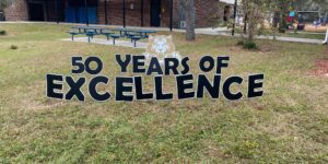 yard cards spell out "50 years of excellence" in front of Westside Elementary School