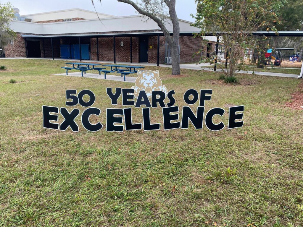 yard cards spell out "50 years of excellence" in front of Westside Elementary School