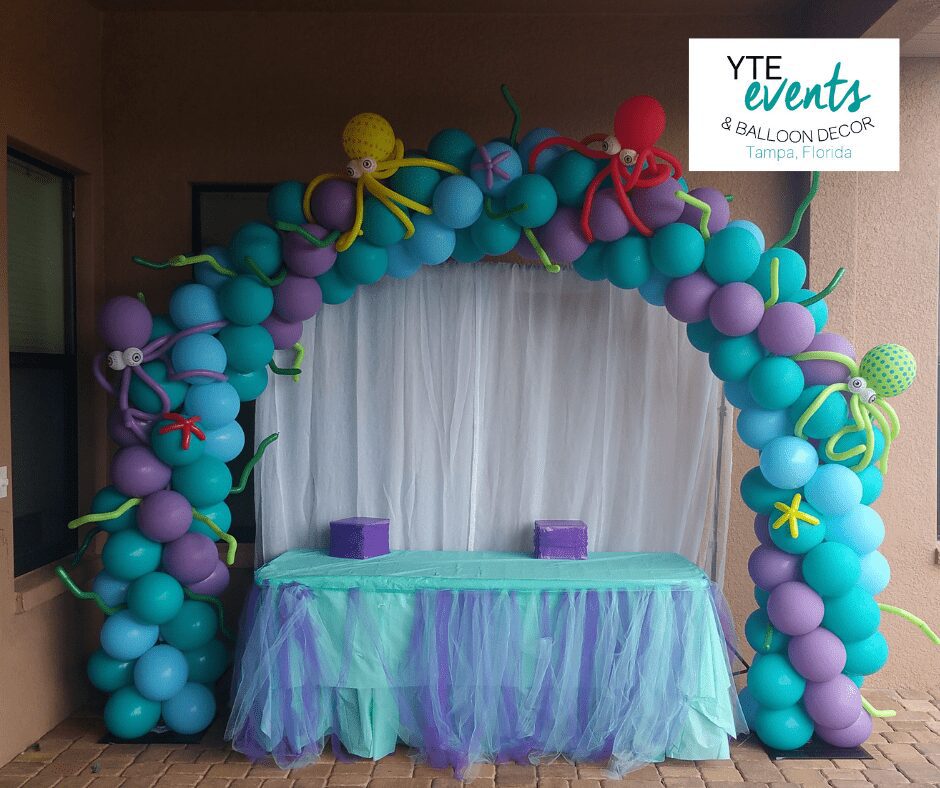 Aquatic themed balloon arches made out of blue, teal and purple balloons and topped with various balloon octopus sculptures.