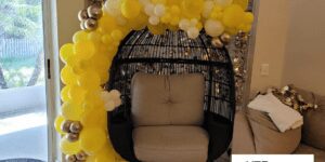 Baby shower balloon decor for private residence made with yellow and gold balloons in a crescent shape.