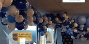 Blue and white balloon ceiling decor where the white balloons are baseball patterned. Copy