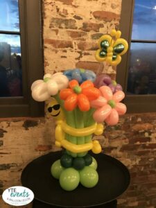 Cool Emoji Smiley Face balloon sculpture bouquet with flowers and butterfly for corporate event in Tampa florida at Armature Works