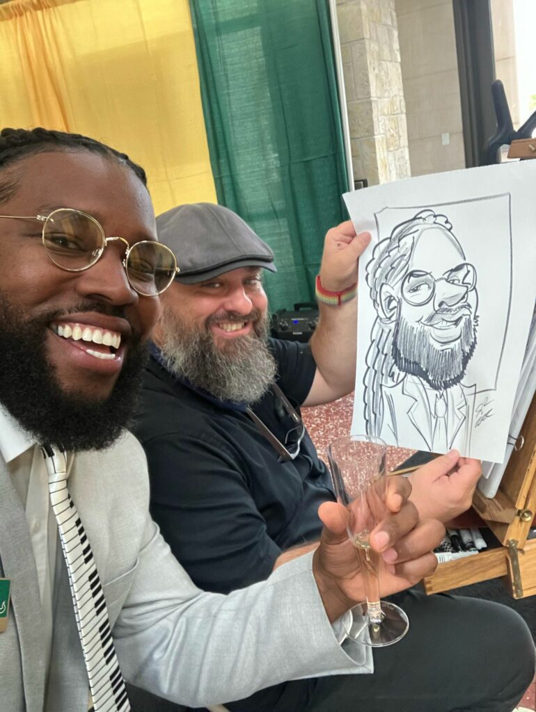 Eddie drawing caricatures USF posing with a client and his portrait