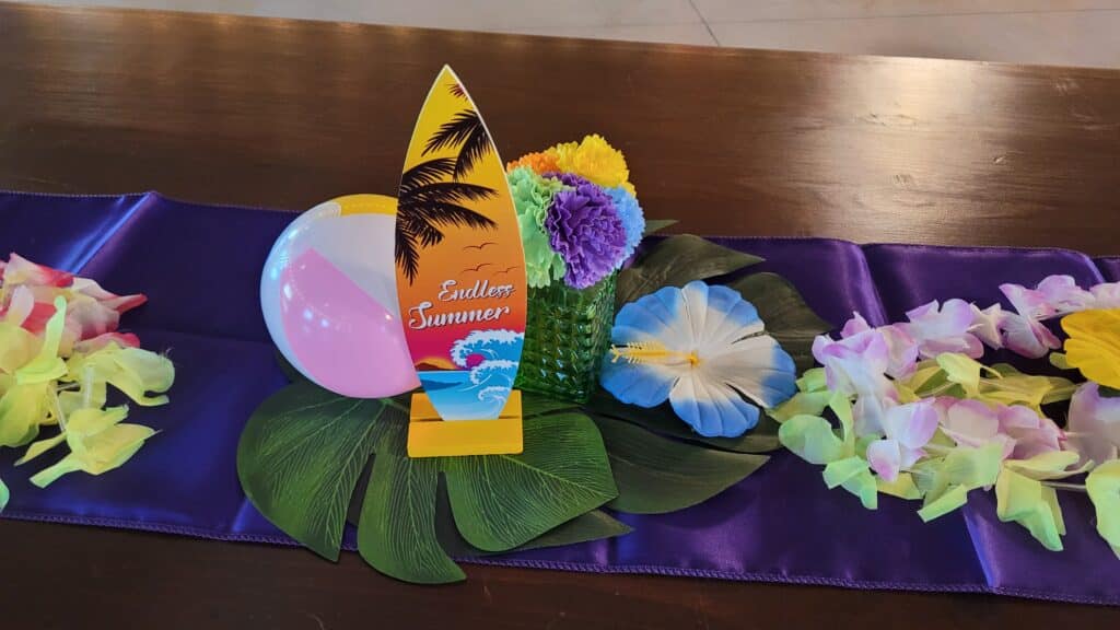 endless summer surfboard centerpiece for table with beach balls and flowers and greenery