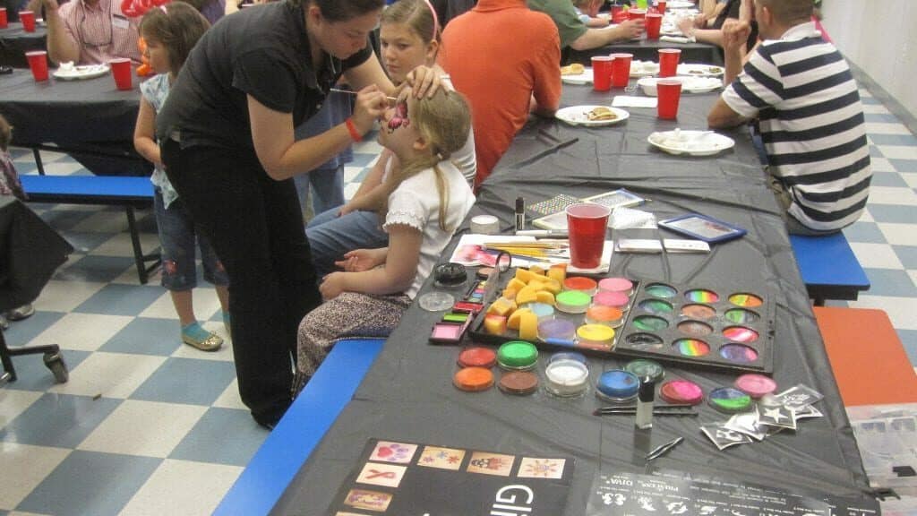 Face Painting Costs and Rates for face painter at event with child at face painting station
