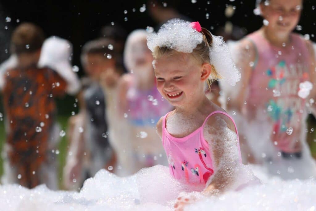 girl smiling pink swimsuit foam party