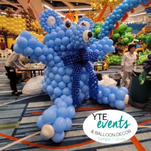 Giant balloon teddy bear in blue with ribbon from give kids the world event in orlando florida