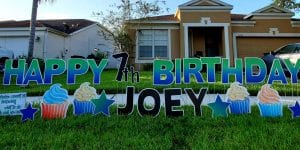 Happy Birthday 7th Party Joey Yard Sign cupcakes and green letters  scaled