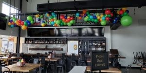 Organic Balloon Decorations over the bar for restaurant opening scaled