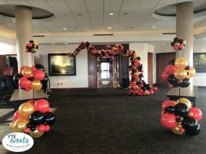 Organic topiary columns and organic arch in red gold black for UT openning week of college at University of Tampa