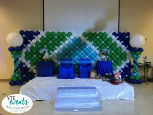 Stage backdrop wall for baby shower event with blue teal white and green