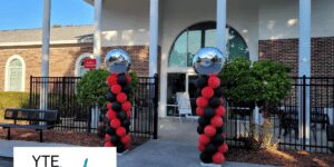 Tampa day school graduation with red and black spiral columns and foil toppers.
