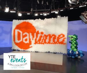 White and orange balloon wall and alligator balloon sculpture for Daytime.