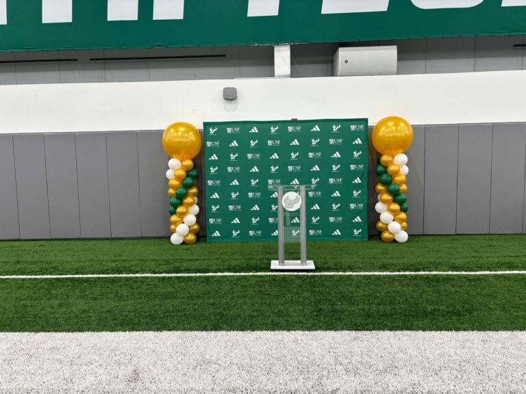 balloon-columns-green-gold-stage-decor-bulls-backdrop