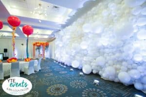 large white balloon wall with table decor pink orange yellow