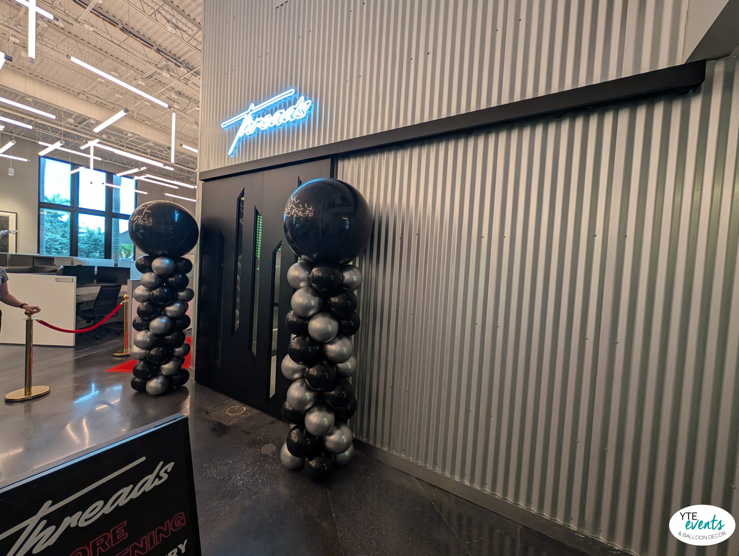 Black and silver balloon columns at entrance of corporate event venue