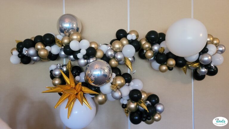 Elegant black, white, gold, and silver balloon garland with custom star designs for a corporate event