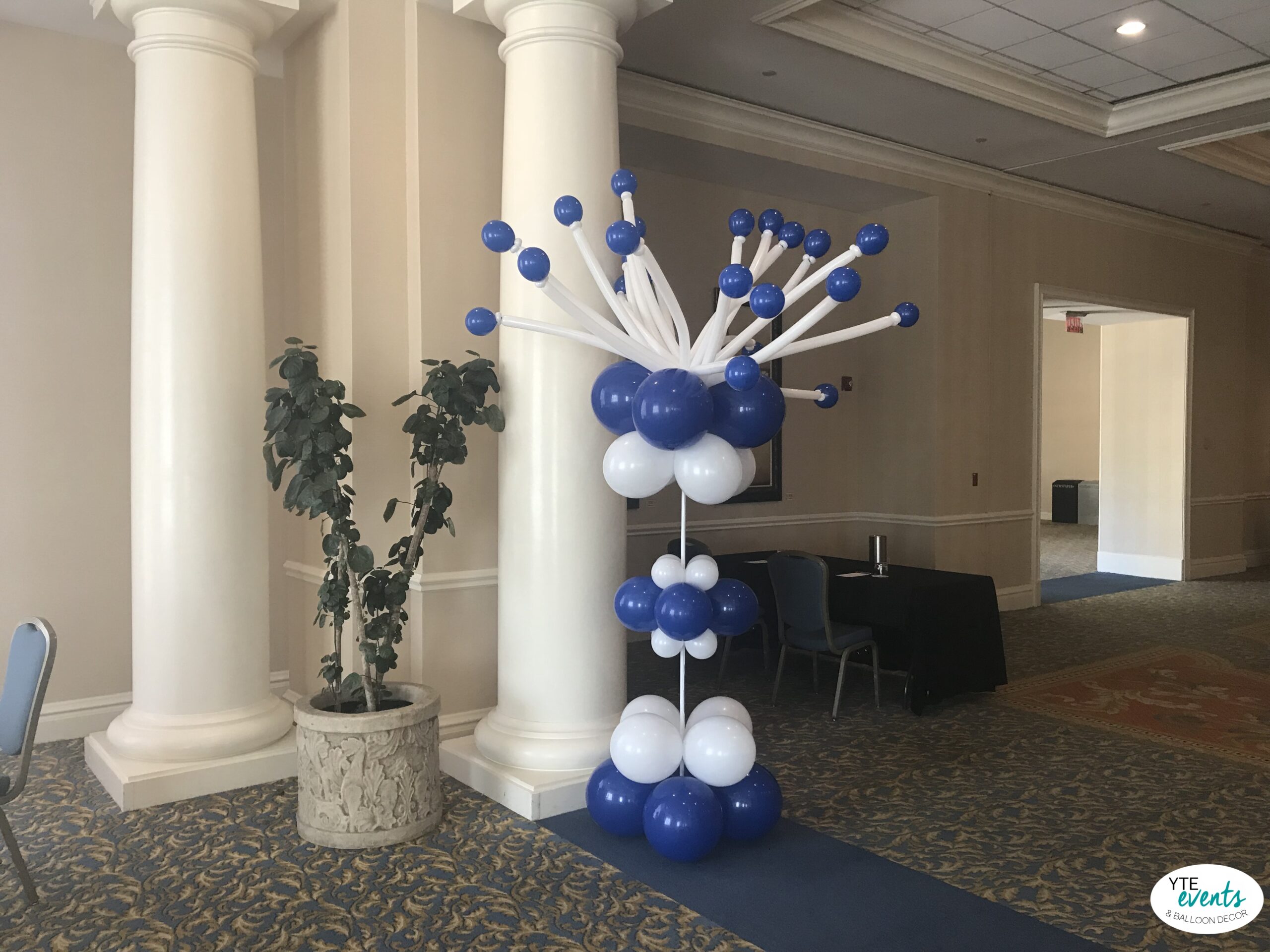 Blue and white balloon centerpiece with starburst design for corporate event decoration