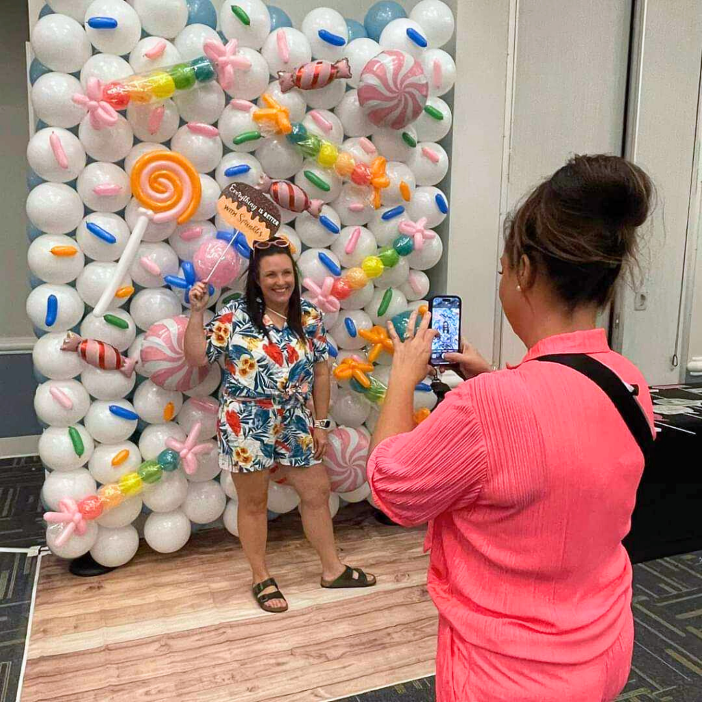 candy-land-party-decor-wall-of-sprinkles- woman taking-picture of another woman