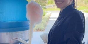 Photo of a woman holding cotton candy at an outdoor event
