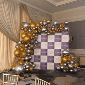 gold and silver balloon garland organic on checkered backdrop for special event