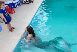 Mermaid greets birthday girl poolside for her party