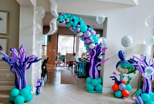mermaid themed birthday party balloon decor with mermaid arch and under the sea theme