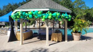 poolside gazebo with green balloon decor around the eaves