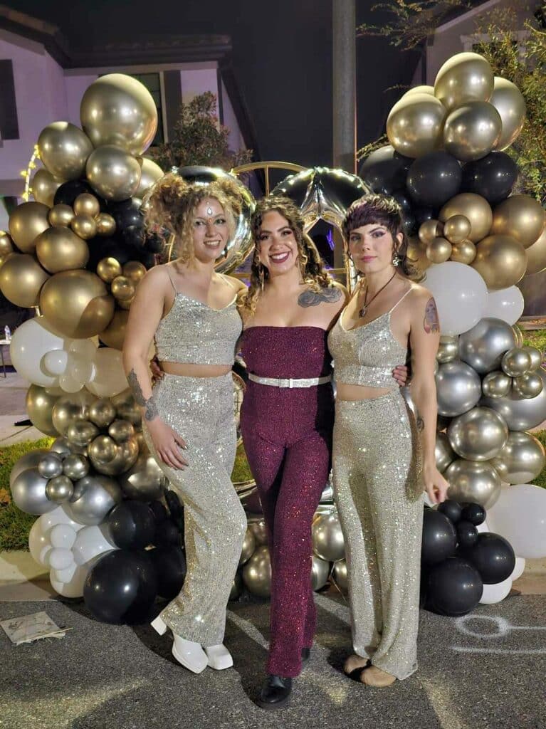three-fire-performers-in-front-of-gold-silver-white-and-black-balloons-nye-edited.
